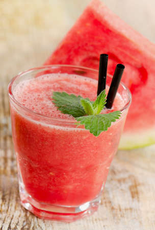 Glass of watermelon smoothie on a wooden tableの写真素材