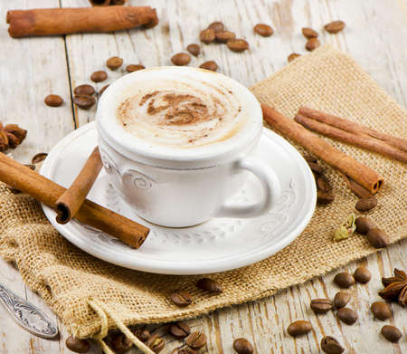 cup of coffee with spices on a wooden tableの写真素材