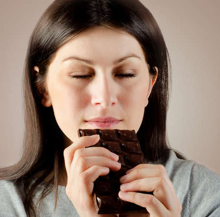 Young beautiful woman with with a chocolate barの写真素材