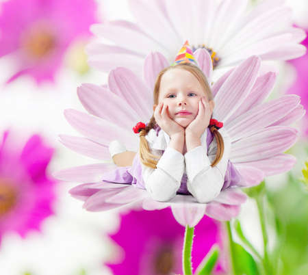 Little happy girl  lying  on spring flowerの写真素材