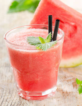 Glass of watermelon smoothie on a wooden table. Selective focusの写真素材