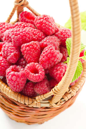 Fresh raspberries in the basket isolated on white backgroundの写真素材