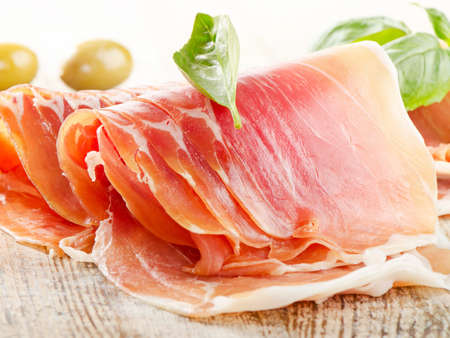 Slices of cured ham on wooden tableの写真素材
