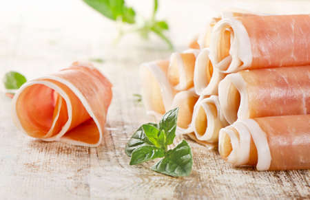 Slices of cured ham on wooden tableの写真素材