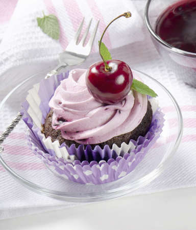 Cupcake with cherry on a wooden tableの写真素材