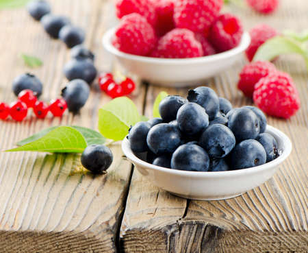 Raspberries and blueberries on wooden tableの写真素材