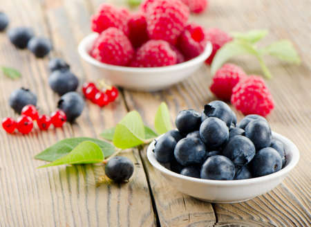 Raspberries and blueberries on wooden tableの写真素材