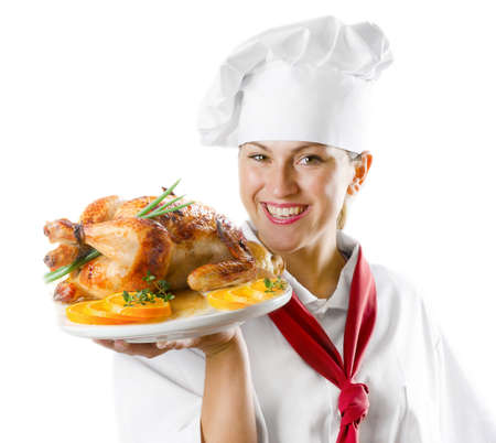Young woman chef holding a plate with chicken isolated on whiteの写真素材