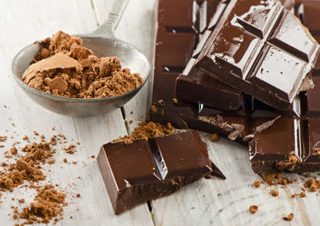 Cocoa powder and broken chocolate bar and on a wooden table. Selective focusの写真素材