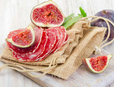 fresh figs and salami on  wooden table. Selective focusの写真素材