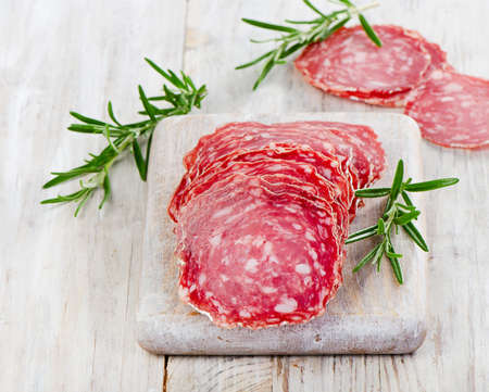 Slices of salami on wooden table. Selective focusの写真素材