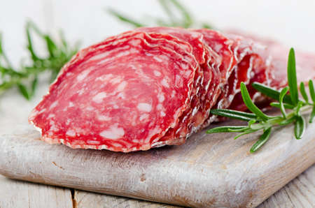 Slices of salami on wooden table. Selective focusの写真素材