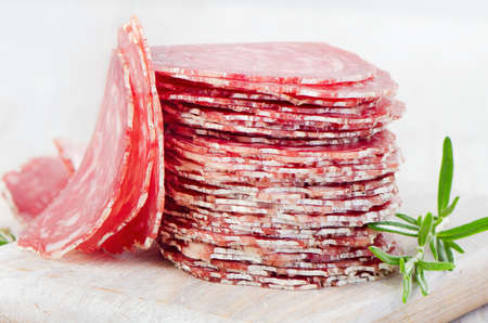 Slices of salami on wooden table. Selective focusの写真素材