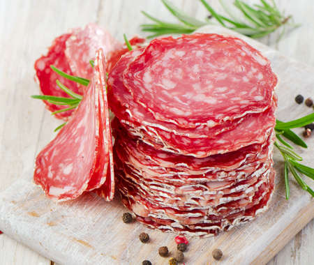 Slices of salami on wooden table. Selective focusの写真素材