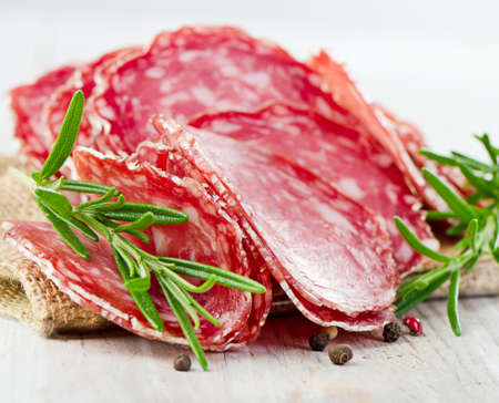 Slices of salami on wooden table. Selective focusの写真素材