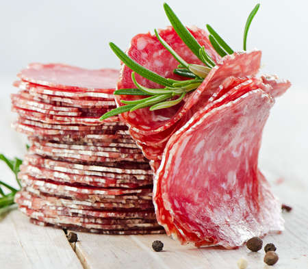 Slices of salami on wooden table. Selective focusの写真素材