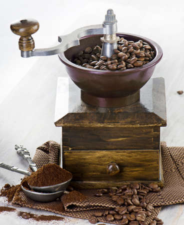 Coffee and old-fashioned coffee grinder on wooden table  の写真素材