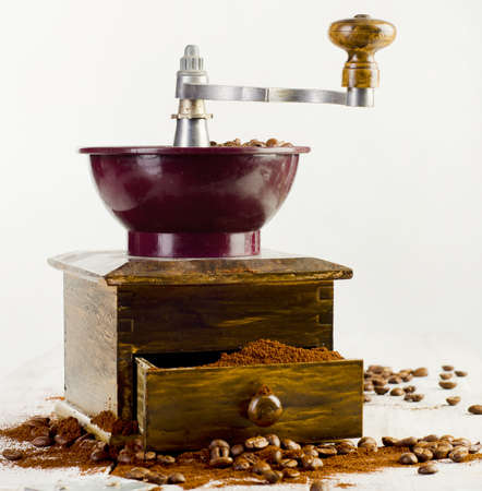 Coffee and old-fashioned coffee grinder on wooden table の写真素材