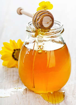 Glass jar of honey with wooden stick.Selective focusの写真素材