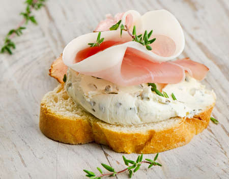 Baguette and cream cheese with herbs. Selective focusの写真素材