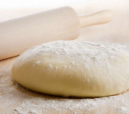 Dough with rolling pin on wooden table. Selective focusの写真素材