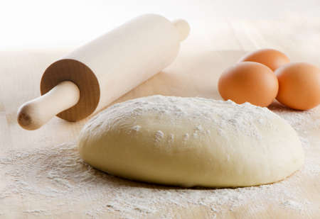 Dough with rolling pin on wooden table. Selective focusの写真素材