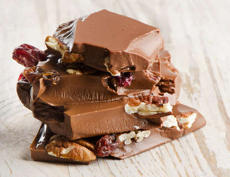 Broken chocolate bar and nuts on wooden table. Selective focusの写真素材