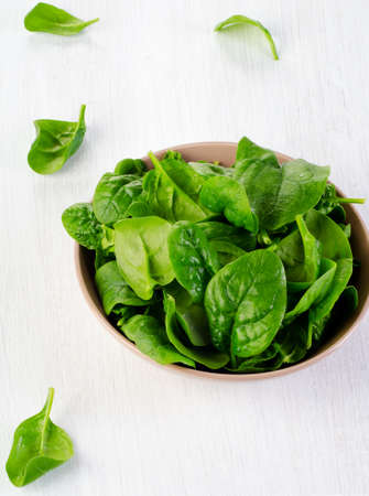 Fresh green spinach leaves on a wooden table