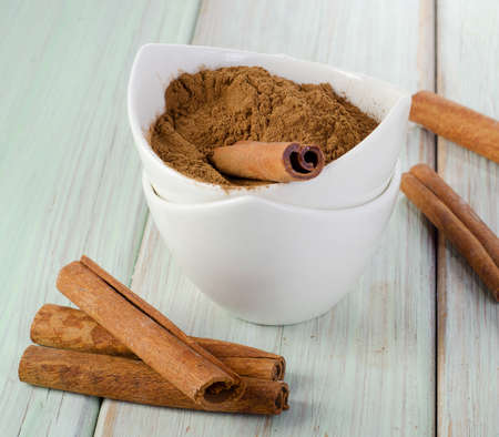Cinnamon sticks and powder on wooden table