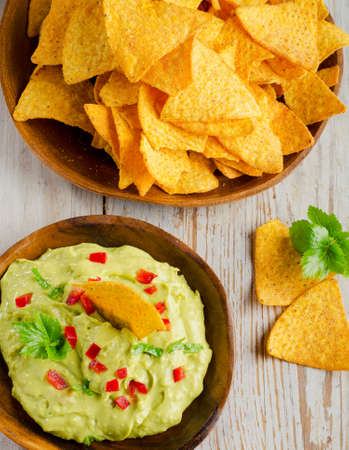 Corn chips and guacamole on wooden tableの写真素材