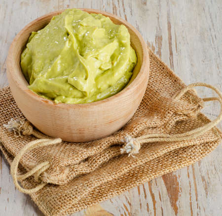 Bowl with guacamole on wooden tableの写真素材
