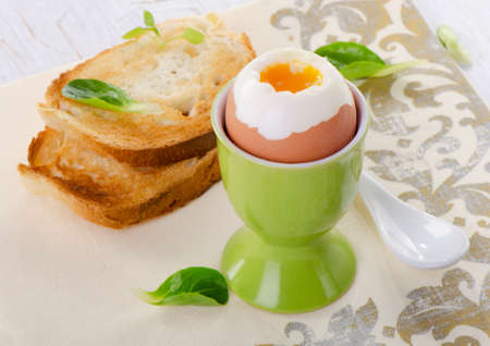 Soft boiled brown egg in eggcup. Selective focusの写真素材