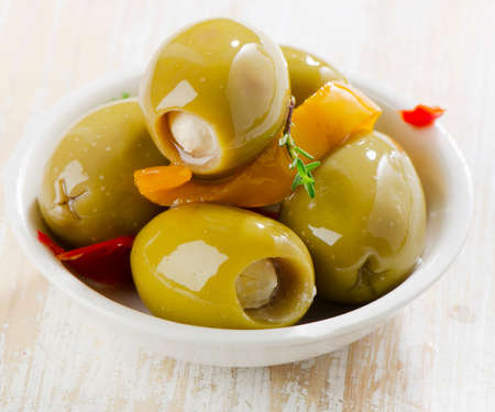 Green olives in a white bowl .  Selective focusの写真素材