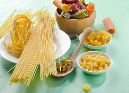 Different types of pasta on a wooden tableの写真素材