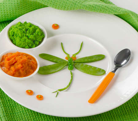 Pureed vegetables for baby with decoration on a white plate. Healthy baby foodの写真素材