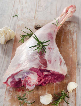 Raw lamb leg on a wooden table.の写真素材