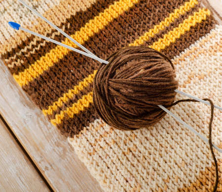 Knitting needles and yarn on a wooden