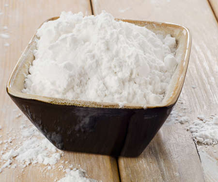 potato starch in a clay bowl on wooden tableの写真素材