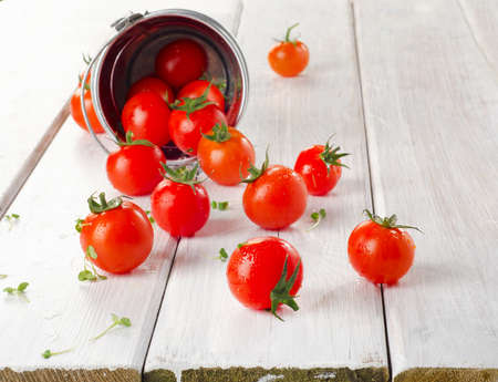 Fresh  cherry tomatoes with herbs on a wooden table. Selective focusの写真素材