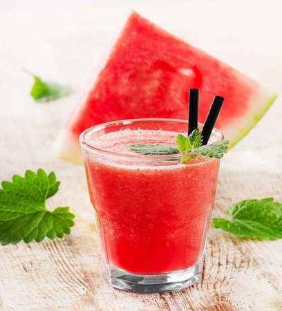 Glass of watermelon smoothie on a wooden table. Selective focusの写真素材