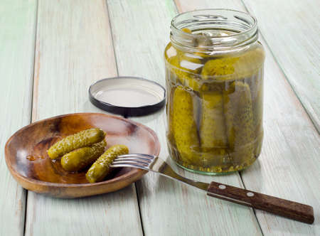 pickled cucumbers on a plate and glass jar . Selective focusの写真素材