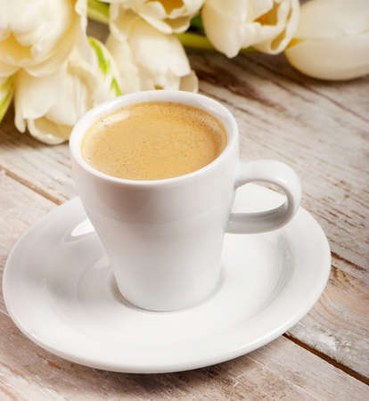 Coffee cup and white tulips. Selective focusの写真素材