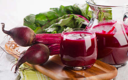 Beetroot juice and bunch of fresh beetroots with leavesの写真素材