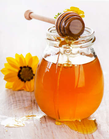 Jar of honey on a wooden tableの写真素材