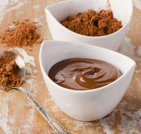 bowl of chocolate cream and cocoa powder on wooden table. Selective focusの写真素材
