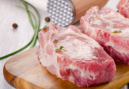 pork steaks on a wooden board. Selective focusの写真素材