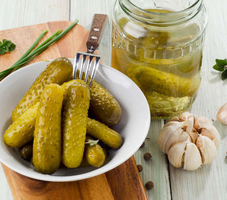 pickled cucumbers on a plate and glass jar . Selective focusの写真素材