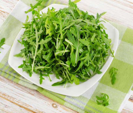 Fresh arugula salad on a white plateの写真素材