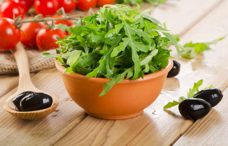Fresh arugula salad on a wooden table. Selective focusの写真素材