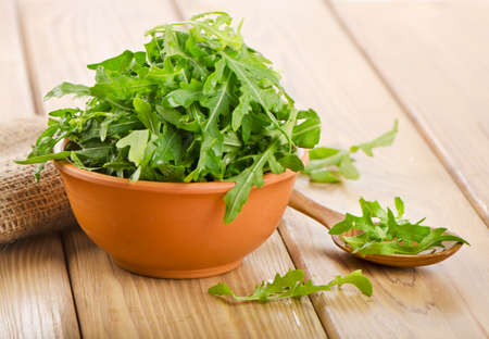 Fresh arugula salad on a wooden table. Selective focusの写真素材